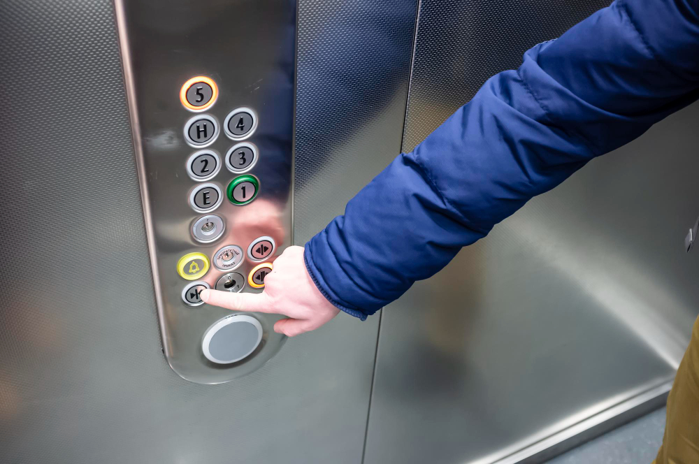 ręka klikająca przyciski w windzie